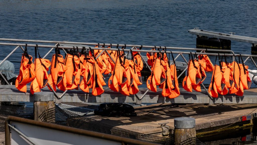 Chalecos salvavidas naranjas colgados en la barandilla de un pantalán en la marina de Kühlungsborn (Alemania)