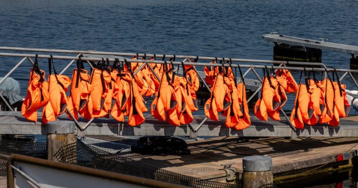 Chalecos salvavidas naranjas colgados en la barandilla de un pantalán en la marina de Kühlungsborn (Alemania)