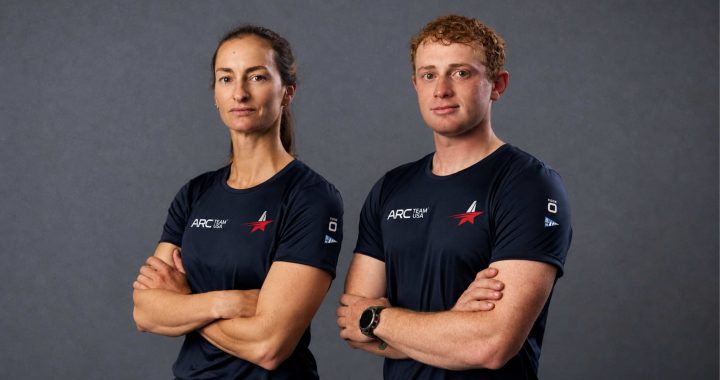 Annie Haeger y Ben Rosenberg, nuevos regatistas del AC75 de ARC Team USA, posan con los brazos cruzados y la camiseta del equipo