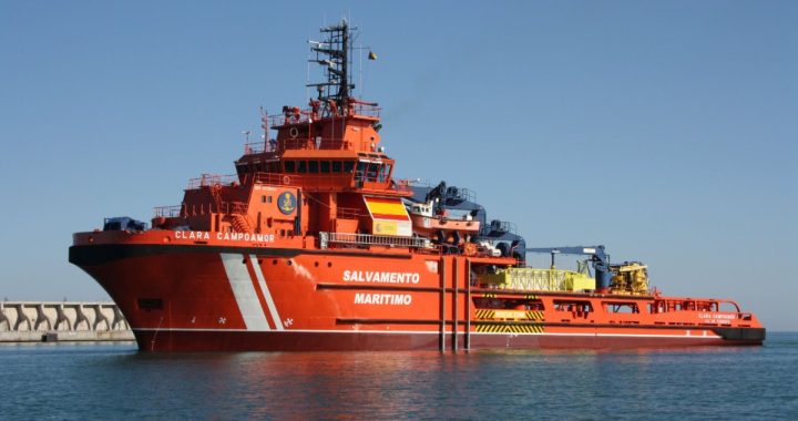 El buque polivalente Clara Campoamor, de Salvamento Marítimo, con el casco naranja, junto a un dique de abrigo
