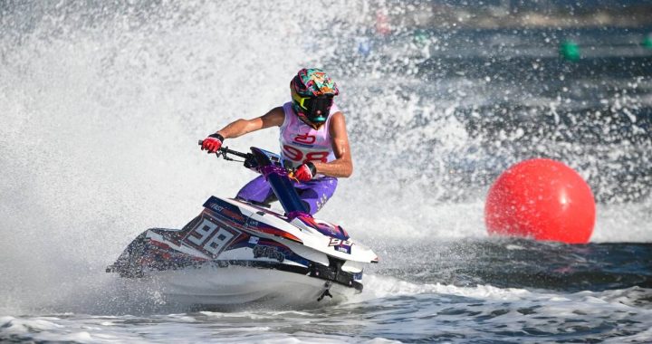 Piloto de moto de agua de pie trazando una curva junto a una boya roja durante el Gran Premio de Olbia