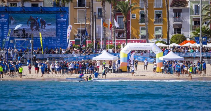 Una tripulación de surfski doble llega a la orilla de la playa Centro de Villajoyosa, junto al arco de meta y ante el público del Mundial de kayak de mar