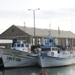 Barcas amarradas en el puerto pesquero de Palamós con el edificio del Museu de la Pesca al fondo