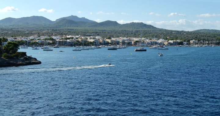 Bahía de Portocolom, en Mallorca, con veleros y lanchas fondeados frente al pueblo