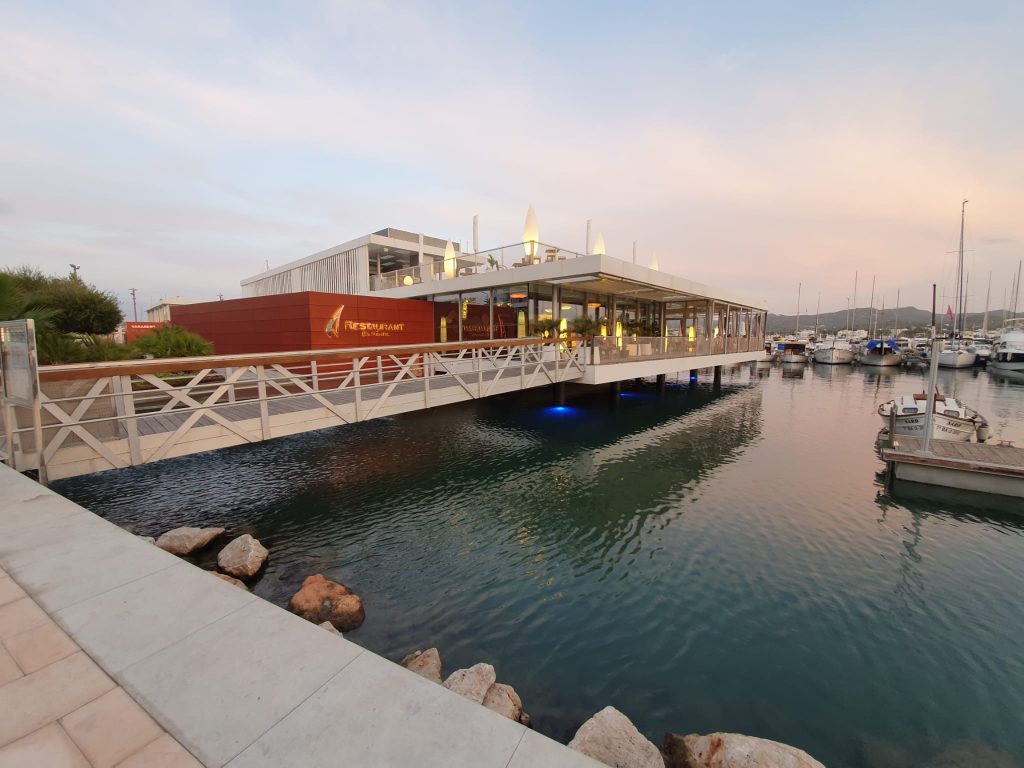 Pantalanes y edificio del club náutico en el puerto de Sant Antoni de Portmany (Ibiza), foto de archivo de 2020