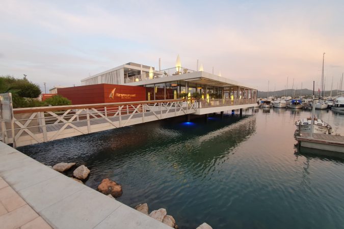 Pantalanes y edificio del club náutico en el puerto de Sant Antoni de Portmany (Ibiza), foto de archivo de 2020