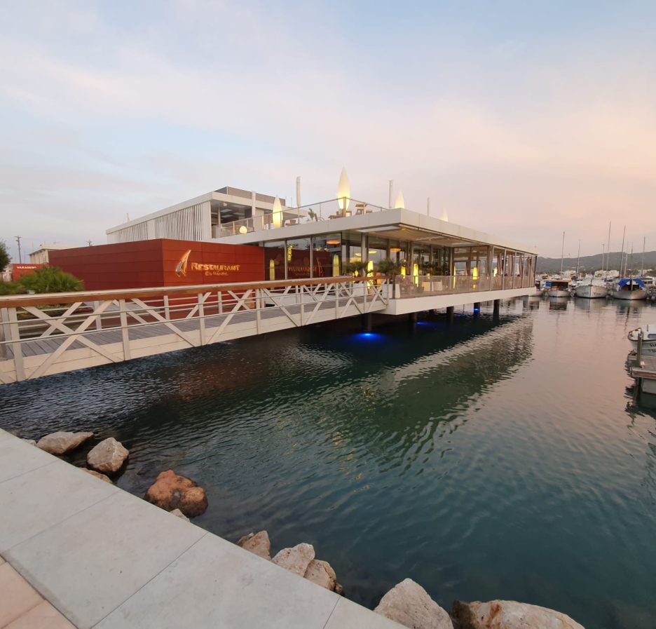 Pantalanes y edificio del club náutico en el puerto de Sant Antoni de Portmany (Ibiza), foto de archivo de 2020