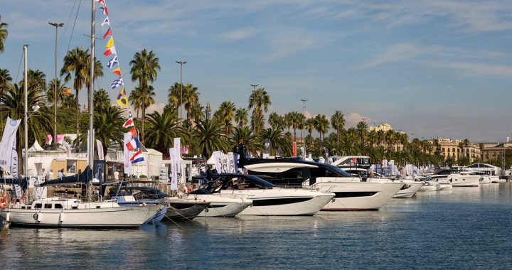 Embarcaciones a motor y veleros amarrados en los pantalanes del Salón Náutico de Barcelona en el Port Vell, con palmeras al fondo