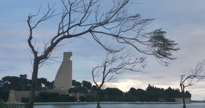 Atardecer en el puerto de Brindisi, con el Monumento al Marinero de Italia al otro lado de la dársena