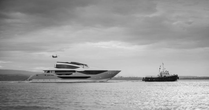 El primer Sunseeker 134 navega remolcado por un remolcador hacia Poole, en una fotografía en blanco y negro con un helicóptero al fondo