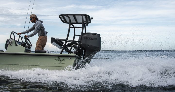 Pescador al timón de un bote de bajos impulsado por un fueraborda Suzuki negro mate navegando a velocidad