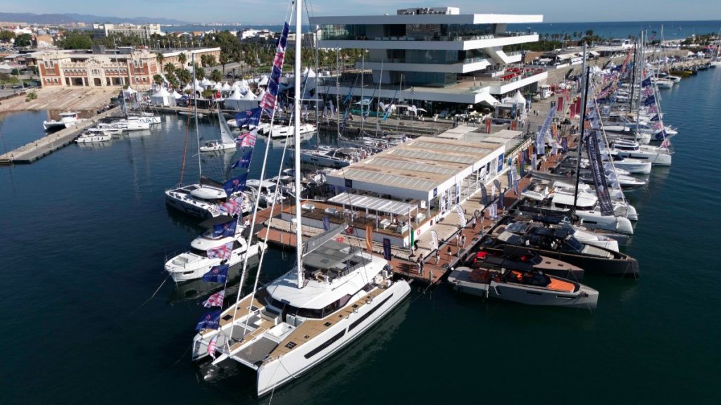 Vista aérea de los pantalanes de Marina Port Valencia con catamaranes y barcos a motor expuestos frente al edificio Veles e Vents durante el Valencia Boat Show